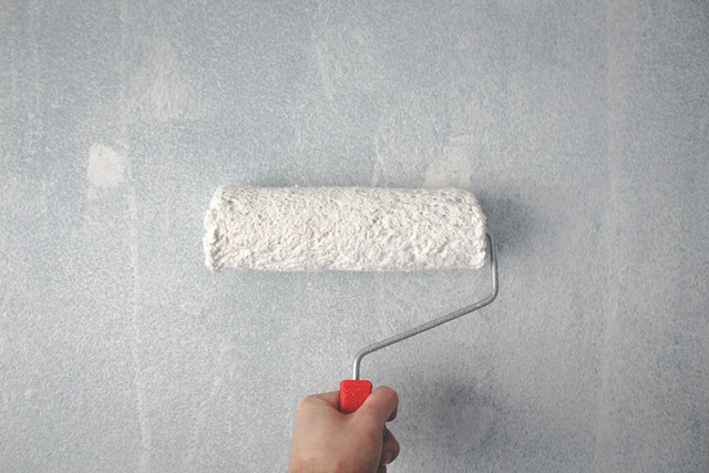 a paint roller being used against a wall