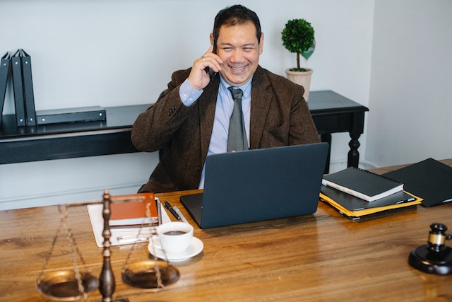 Person wearing a brown suit making a phone call in an office
