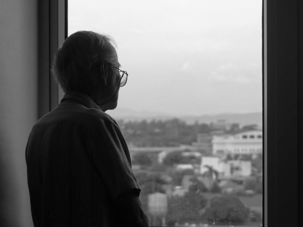 older man looking out the window