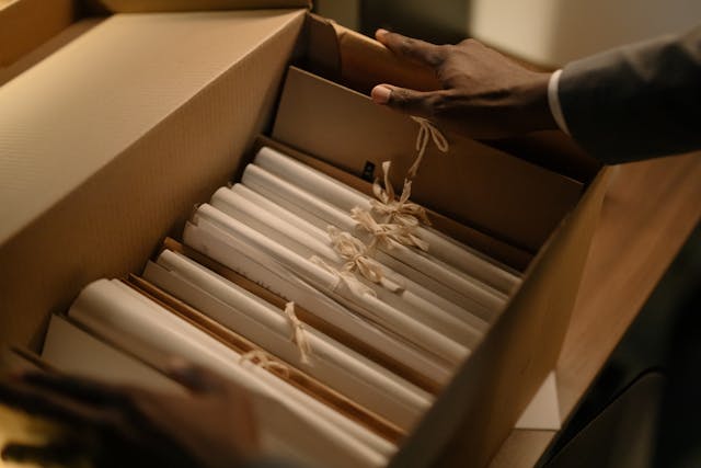 person-holding-box-of-paper-documents