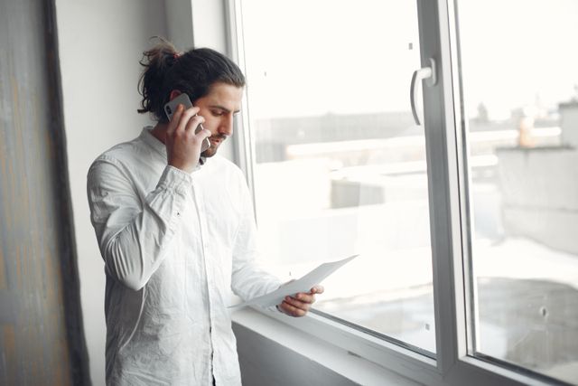 person on a phone call holding a document